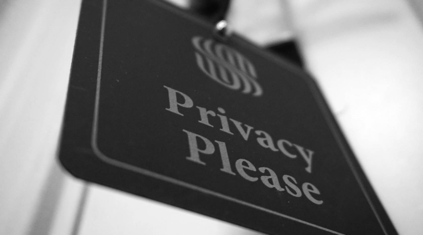 Silver font on a black sign with a symbol and the text "Privacy" at an angle of 45 degrees.